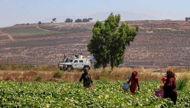 Farmers work in the plain of Marjayoun on the outskirts of the southern Lebanese village of Khiam, opposite the Israeli town of Metula along the border with Israel