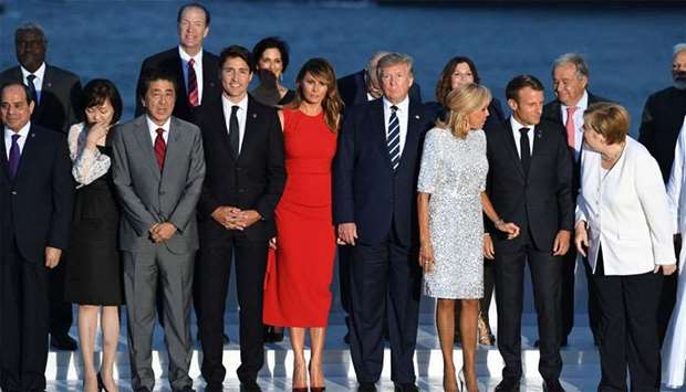 French President Emmanuel Macron and his wife Brigitte Macron, U.S. President Donald Trump and First Lady Melania Trump, Japan's Prime Minister Shinzo Abe, Canada's Prime Minister Justin Trudeau and German Chancellor Angela Merkel pose for a family photo with invited guests during the G7 summit in Biarritz, France