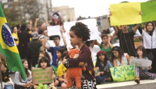 A girl attends a protest called by intellectuals and artists against the destruction of the Amazon rainforest, at Ipanema Beach in Rio de Janeiro, Brazil.