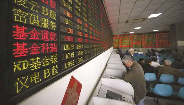 Investors look at computer screens showing stock information at a brokerage house in Shanghai. The Composite index closed up 1.4% to 2,902.19 points yesterday.