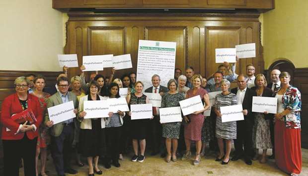 Cross-party MPs hold signs after signing the Church House Declaration after an event about opposing the suspension of parliament to prevent no-deal Brexit in London, , yesterday.