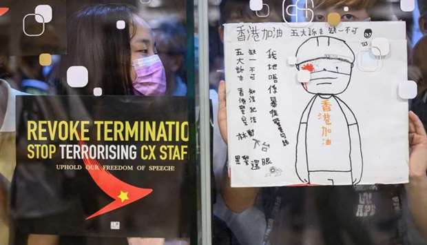 Protesters stick posters outside a shopping mall in a rally to support Cathay Pacific staff in Hong Kong. AFP