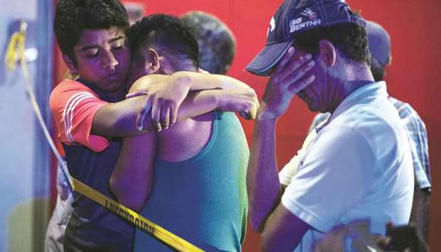 People wait outside a bar where 23 people were killed by a fire in Coatzacoalcos, Veracruz, yesterday.