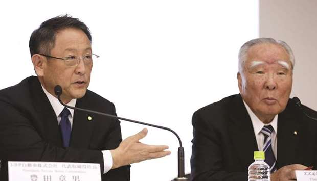 Akio Toyoda, president of Toyota Motor Corp (left), gestures as he speaks as Osamu Suzuki, chairman of Suzuki Motor Corp, looks on during a news conference in Tokyo. The Japanese car makers will take small equity stakes in each other, the  companies said yesterday, as they seek to develop newer technologies and meet sweeping changes upending the global auto industry.