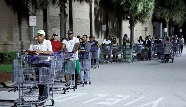 Shoppers wait in a long line for a Sam's Club store to open before sunrise, as people rushed to buy supplies ahead of the arrival of Hurricane Dorian in Kissimmee, Florida