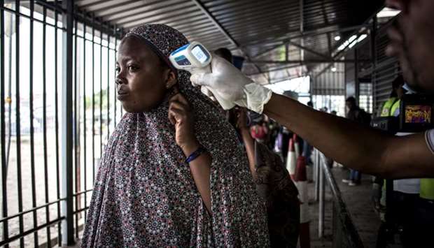 In this file photo taken on July 16, 2019 in Goma, a woman gets her temperature measured at an Ebola screening station as she enters the Democratic Republic of the Congo from Rwanda.