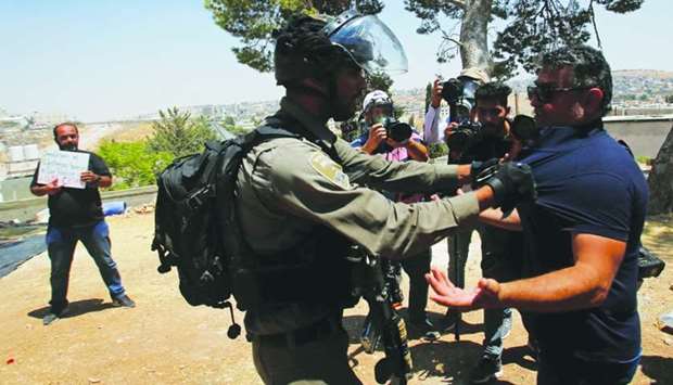 An Israeli border policeman grabs a Palestinian demonstrator during a protest against the Israeli demolitions of Palestinian homes in the village of Sur Baher which sits on either side of the Israeli barrier in East Jerusalem and the Israeli-occupied West Bank