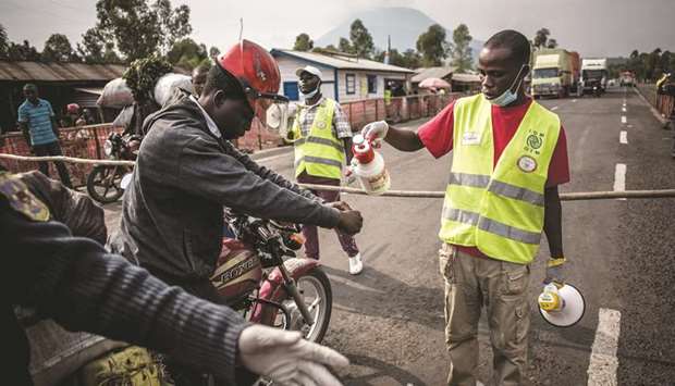 File photo taken on July 16, 2019 in Goma shows a motor taxi driver getting his hands washed at an Ebola screening station on the road between Butembo and Goma.