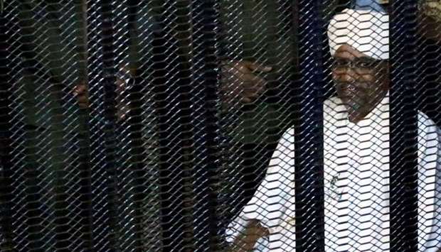 Sudan's former president Omar Hassan al-Bashir sits guarded inside a cage at the courthouse where he is facing corruption charges, in Khartoum, Sudan on August 19, 2019