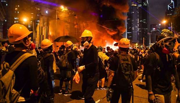 Protesters stand before a barricade they set on fire in the Wan Chai district in Hong Kong.