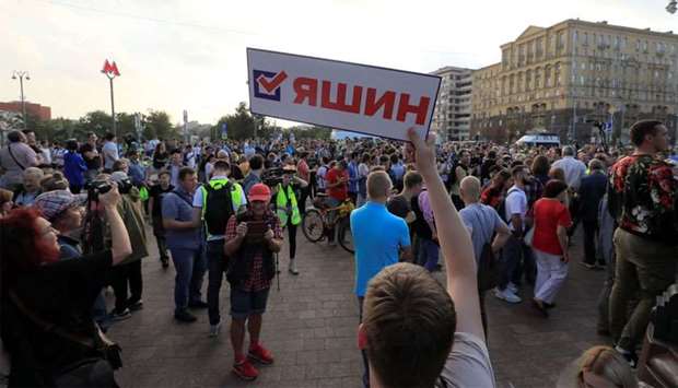 People attend a rally to demand authorities allow opposition candidates to run in the upcoming local election and release protesters, who were detained during recent demonstrations, in central Moscow