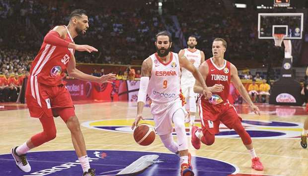 Spainu2019s Ricky Rubio (centre) dribbles past Tunisiau2019s Salah Mejri (left) and Michael Roll (right) during their Basketball World Cup Group C game in Guangzhou yesterday. (AFP)