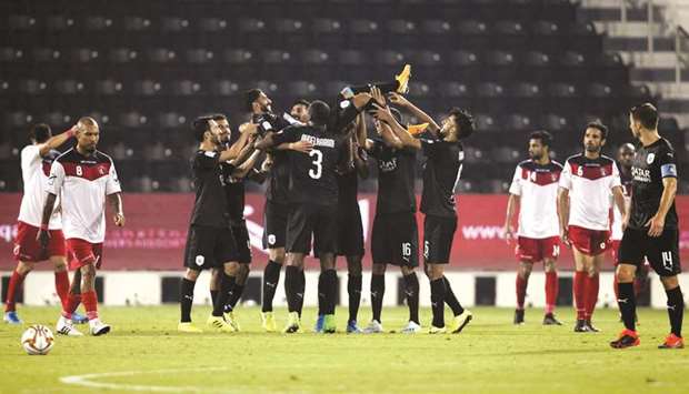 Al Saddu2019s Hassan al-Haydos is tossed in the air by teammates after he scored his 100th goal for the club yesterday. At bottom, Baghdad Bounedjah is congratulated by his teammates.