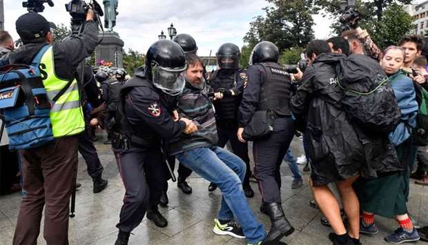 Riot police officers detain a participant of an unsanctioned rally urging fair elections at Moscow's Pushkinskaya Square