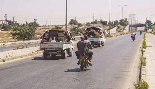 Syrians who were displaced from the south of Idlib province and fled towards its northern border region with Turkey, ride in trucks loaded with belongings along the Bab al-Hawa highway yesterday on their way back home to Idlib following the signing of a truce with government forces. Air strikes on the Idlib region stopped on August 2 after the government announced it had agreed to a truce following more than three months of deadly bombardment.