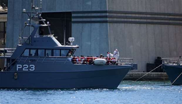 A patrol boat carrying migrants rescued by the Alan Kurdi vessel enters the Maltese harbour