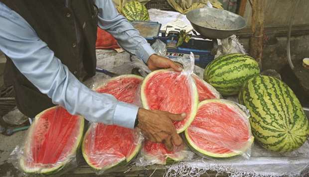 A vendor packs watermelons in plastic bags. From August 14, a ban on plastic bags would come into force in Islamabad.