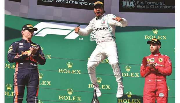 Mercedes driver Lewis Hamilton (centre) celebrates his victory as second-placed Red Bull driver Max Verstappen (left) and third-placed Ferrari driver Sebastian Vettel look on the podium for the Hungarian Grand Prix at the Hungaroring circuit in Mogyorod near Budapest, Hungary, yesterday. (AFP)