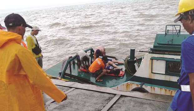 Rescuers retrieve a body from one of the ferries which capsized at a port in Iloilo City.