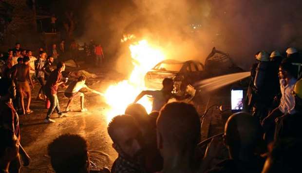 People extinguish a fire from a blast outside the National Cancer Institute, Cairo, Egypt