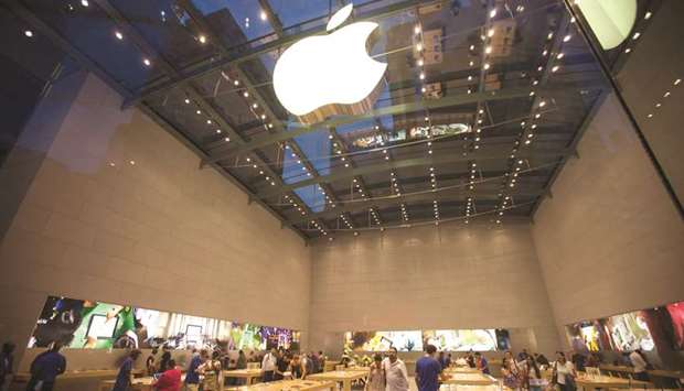 Shoppers look at products at an Apple store in New York. Apple managed to grow its overall revenues, albeit by a modest 1%, to $53.8bn, even as iPhone revenues plunged nearly 12% in the April-June period.