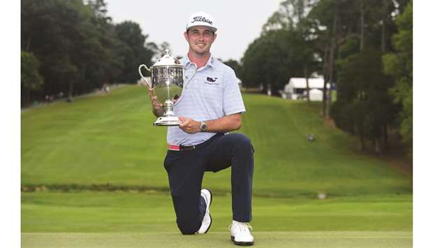 JT Poston of the US celebrates with the trophy after winning the Wyndham Championship at Sedgefield Country Club in Greensboro, North Carolina, on Sunday. (AFP)