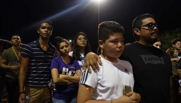 People gather for a vigil a day after a mass shooting at a Walmart store in El Paso, Texas
