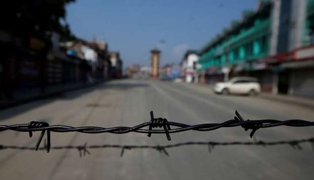 Barbed wire is seen laid on a deserted road during restrictions in Srinagar yesterday