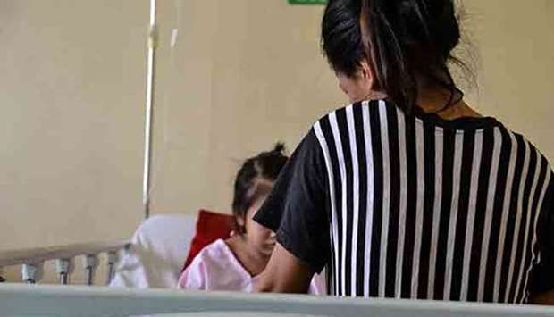 A mother takes care of her daughter suffering from Dengue at the San Lazaro Hospital. Photo courtesy: Enrique Agcaoili/Manila Times