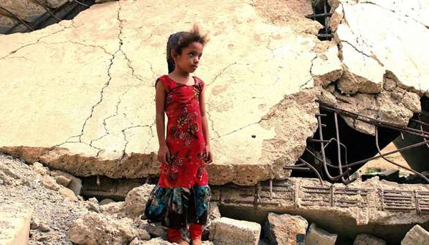A Yemeni girl who was displaced with her family, stands amidst the rubble of a building that was destroyed in reported strikes by Saudi-led coalition forces, in the district of Abs in Yemenu2019s northwestern Hajjah province.
