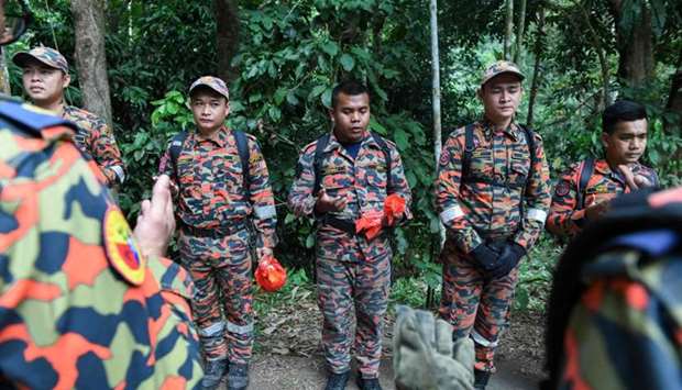 Members of Malaysian K-9 unit pray before taking part in a search and rescue operation for the missing 15-year-old Franco-Irish, Nora Quoirin in Seremban