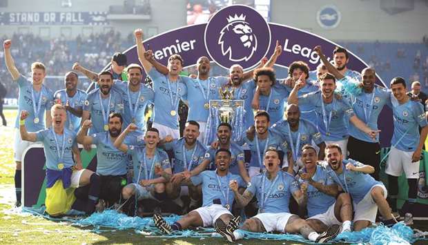 In this May 12, 2019, picture, Manchester City players pose with the trophy as they celebrate winning the Premier League after the match against Brighton & Hove Albion in Brighton, England. (Reuters)