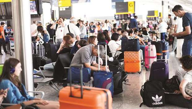 People wait inside Terminal 5 at Heathrow Airport, London, as IT problems caused delays yesterday.