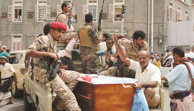 Yemenu2019s southern separatists sit in the back of a vehicle with a coffin of Brigadier General Muneer al-Yafee killed in a Houthi missile attack, during a funeral in Aden yesterday.