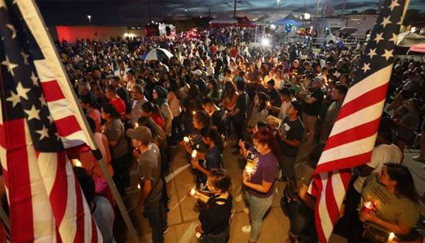 People attend a candlelight vigil at a makeshift memorial honoring victims of a mass shooting which left at least 22 people dead in El Paso
