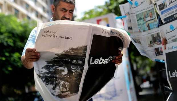 A man checks a copy of the Lebanese local English-language newspaper ,The Daily Star, in the capital Beirut, which refrained from publishing news articles in its print edition today in protest against the ,deteriorating situation, in Lebanon