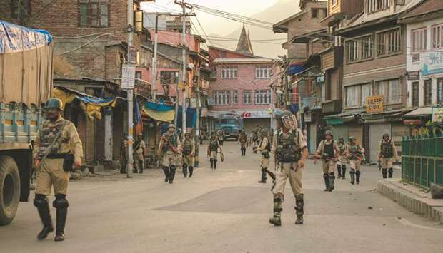 Security personnel walk on a street in Srinagar yesterday as widespread restrictions on movement and a telecommunications blackout remained in place after the government stripped Jammu and Kashmir of its autonomy.