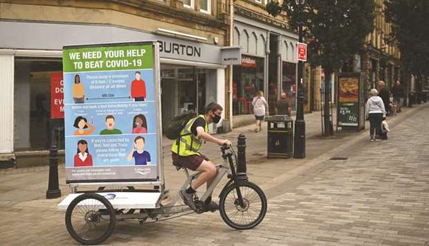 In a promotion funded by Calderdale council, Phil Mearns rides his ad bike displaying advice on how to slow the spread of the coronavirus through the streets of Halifax in northern England yesterday as local lockdown restrictions are reimposed due to a spike in cases of the novel coronavirus in town.