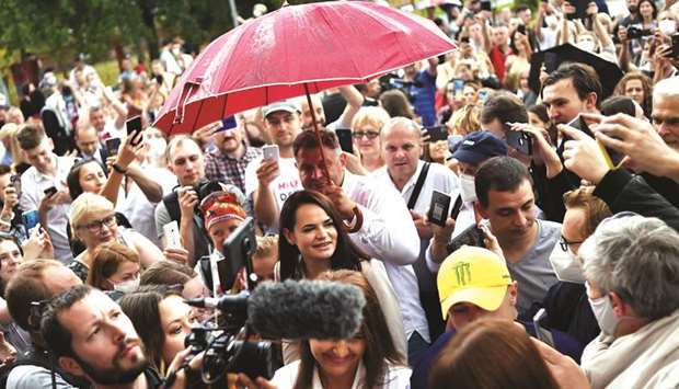 People surround Tikhanovskaya as she arrives to cast her vote at a polling station in Minsk.