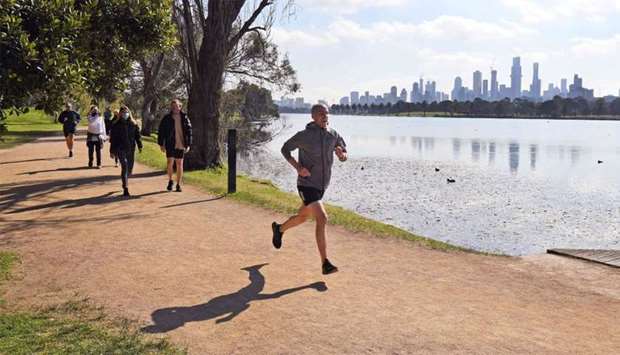 A jogger runs beside Albert Park Lake in Melbourne
