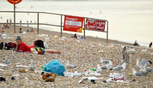 A beachgoer looks across at seagulls pecking on trash on the beach, amid the coronavirus disease (COVID-19) outbreak, in Brighton