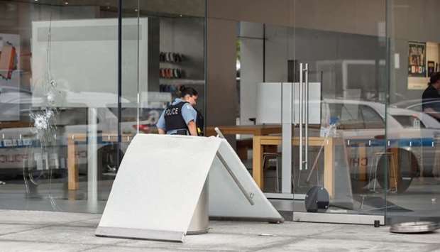 A Chicago Police officer inspects an Apple store that was vandalized in Chicago, Illinois, US