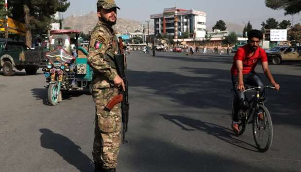 An Afghan policeman stands guard at a check point in Kabul, Afghanistan