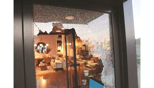 A broken storefront window is seen after parts of the city had widespread looting and vandalism, in Chicago, Illinois, yesterday.