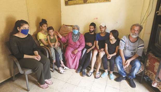Iman al-Ali sits with her family in a room in Tripoli, northern Lebanon.