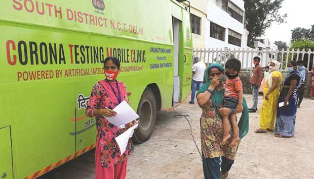People wait to be tested outside a mobile coronavirus testing facility in New Delhi yesterday.