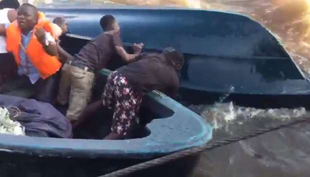 This screenshot from a video shared on social media, rescue workers seen trying to overturn another boat engaged in rescue operations.