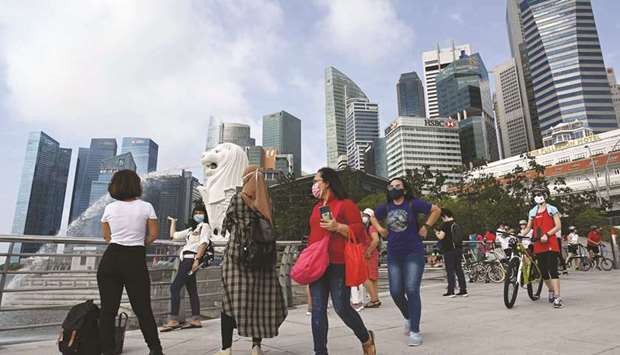People walking past the Merlion statue in Singapore. The virus-hammered economy shrank almost 43% in the second quarter, in a sign that the countryu2019s first recession in more than a decade was deeper than initially estimated, official data showed yesterday.