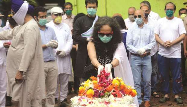 Wife of Air India Express pilot Deepak Sathe places flowers on his coffin during his funeral in Mumbai yesterday. Sathe and 17 others died in the plane crash in Kerala on Friday.