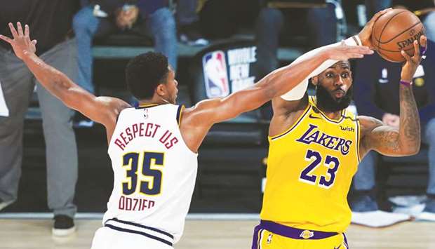 Los Angeles Lakersu2019 LeBron James (23) looks to pass while pressured by Denver Nuggetsu2019 PJ Dozier (35) during the second half of their NBA game on Monday.